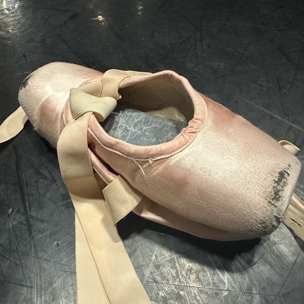 Thoroughly worn pink pointe shoes used by professional ballerina